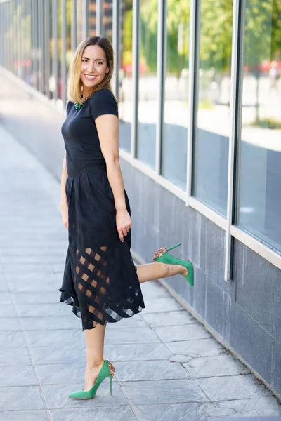 Mulher atraente vestindo saia e saltos altos verdes ao ar livre. — Fotografia de Stock