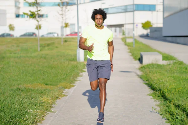 Schwarzer, athletischer Mann läuft in Stadtpark. — Stockfoto