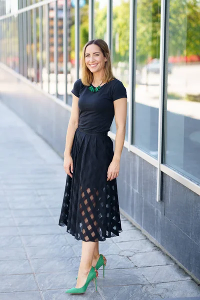 बाहेर स्कर्ट आणि हिरव्या उच्च हील परिधान आकर्षक महिला . — स्टॉक फोटो, इमेज