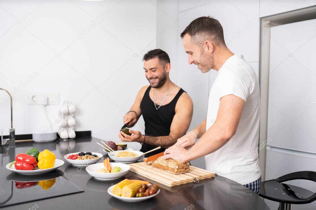 Gay couple cooking healthy vegan food together at home.