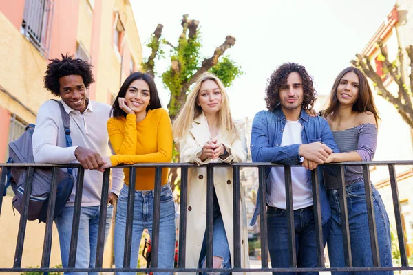 Grupo multiétnico de amigos se reunieron en la calle apoyados en una barandilla. — Foto de Stock