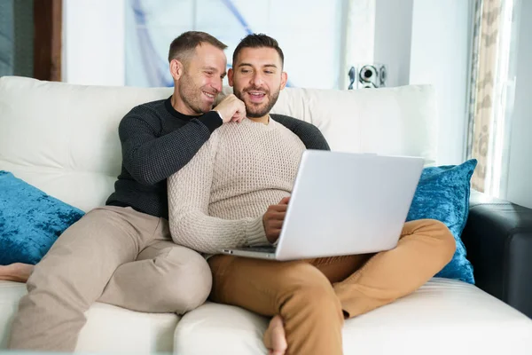 Pareja gay consultando sus planes de viaje junto con un portátil. —  Fotos de Stock