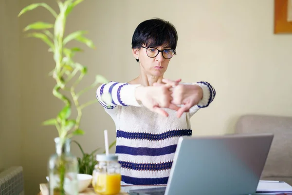 Mujer de mediana edad teletrabajo tomando un descanso estiramiento. —  Fotos de Stock