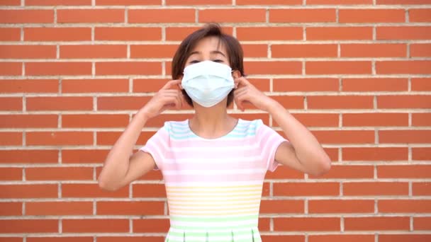 Little girl removing covid-19 mask, end of pandemic. Caucasian person. Slow motion video. — Stockvideo