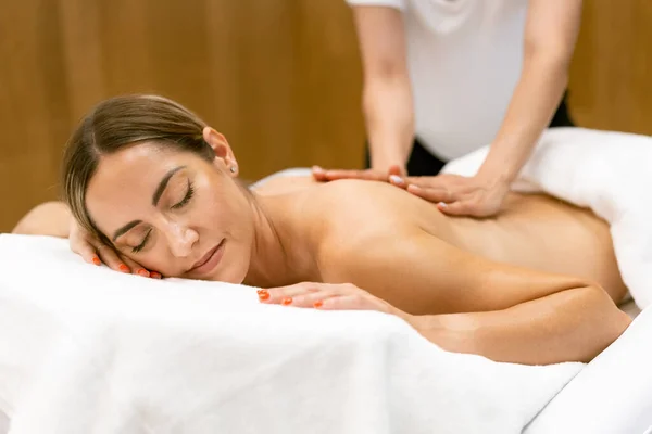 Mulher de meia-idade tendo uma massagem nas costas em um salão de beleza. — Fotografia de Stock