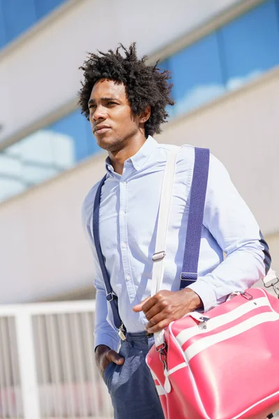 Black worker walking near an office building with a sports bag. — Stock Photo, Image