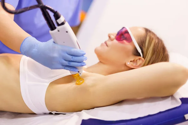 Woman receiving underarm laser hair removal at a beauty center. — Stock Photo, Image