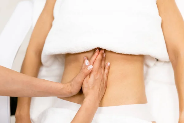 Middle-aged woman having a belly massage in a beauty salon. — Stock Photo, Image