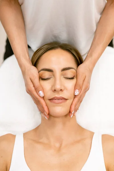 Mujer de mediana edad que tiene un masaje en la cabeza en un salón de belleza. — Foto de Stock