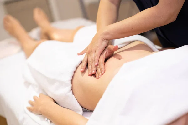Kadın bir fizik tedavi merkezinde karın masajı yaptırıyor.. — Stok fotoğraf