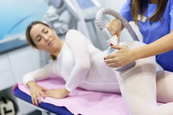 Женщина в специальном белом костюме с антицеллюлитным массажем со спа-аппаратом — стоковое фото
