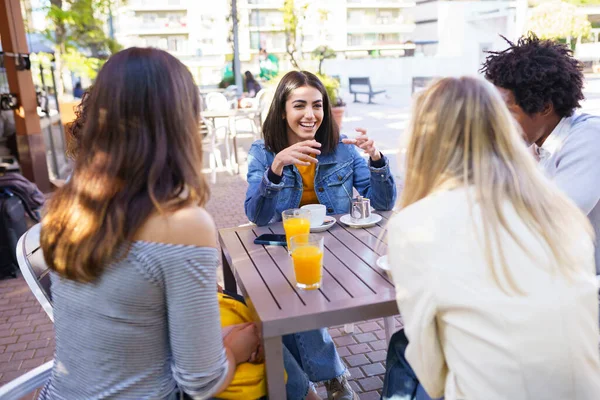 Multi-etnische groep vrienden die samen een drankje drinken in een buitenbar. — Stockfoto