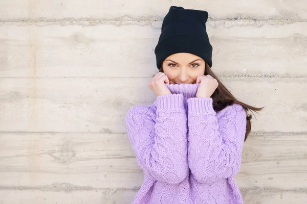 Счастливая молодая женщина в зимней шляпе у городской стены. — стоковое фото