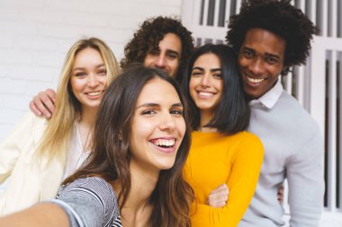 Çok ırklı bir grup arkadaş dışarıda eğlenirken selfie çekiyorlar..