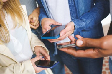 Akıllı telefon kullanan tanınmayan genç insanların elleri.