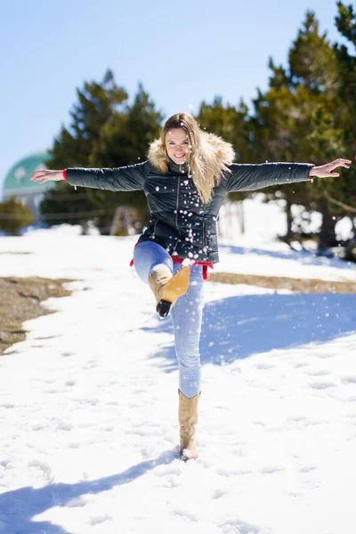 Blondýny šťastný žena kopání sníh ve sněhem pokrytém lese v horách — Stock fotografie