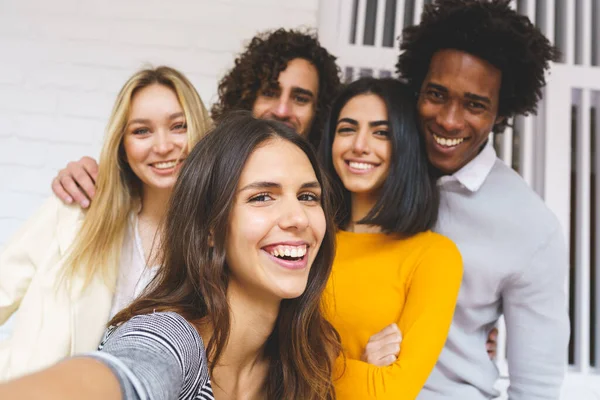 Multi-ethnic group of friends taking a selfie together while having fun outdoors. — Stock Photo, Image