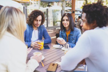 Bir sokak barının terasında içki içen çok ırklı bir grup öğrenci..
