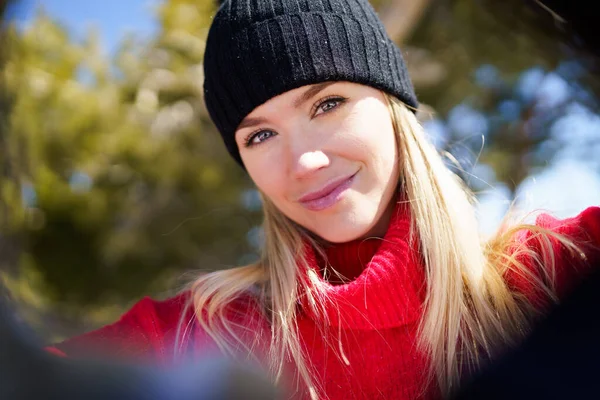 Ung blond kvinna som tar en selfie i en snöig fjällskog på vintern. — Stockfoto