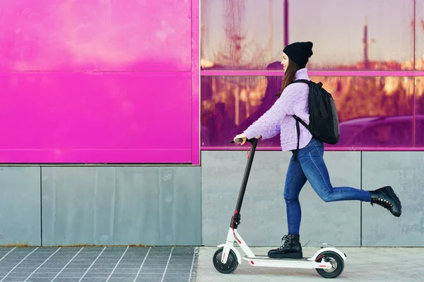 Jeune femme dans la vingtaine chevauchant un scooter électrique. — Photo