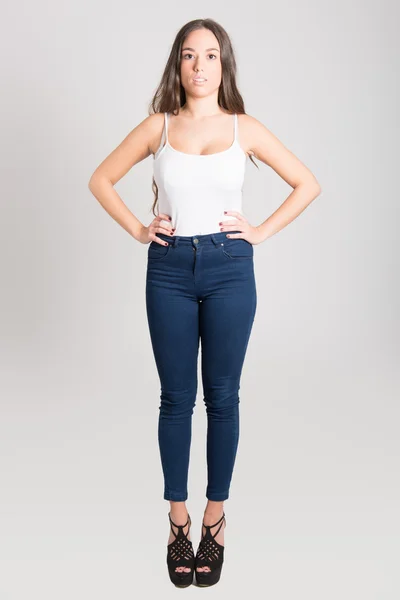 Žena s dlouhými vlasy, na sobě bílé tričko a modré džíny — Stock fotografie
