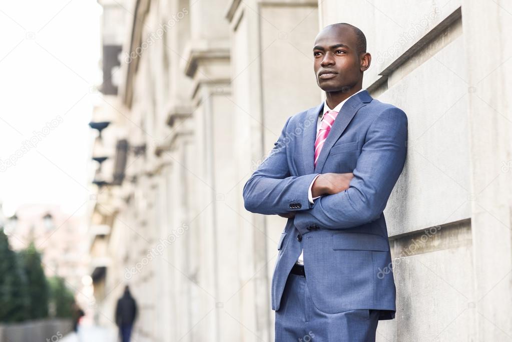 Handsome black man wearing suit in urban background