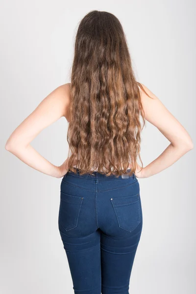 Žena s dlouhými vlasy, na sobě bílé tričko a modré džíny — Stock fotografie