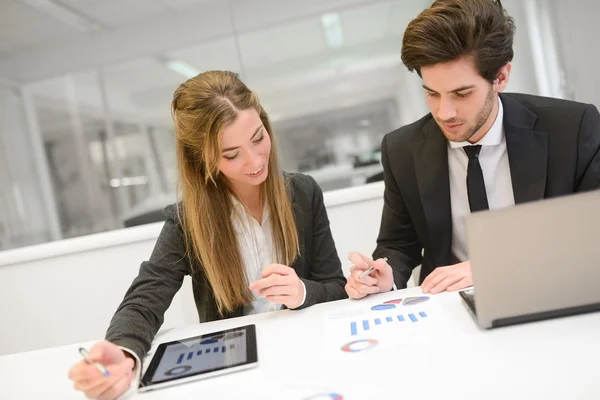 Zakenmensen werken rond tafel in modern kantoor — Stockfoto