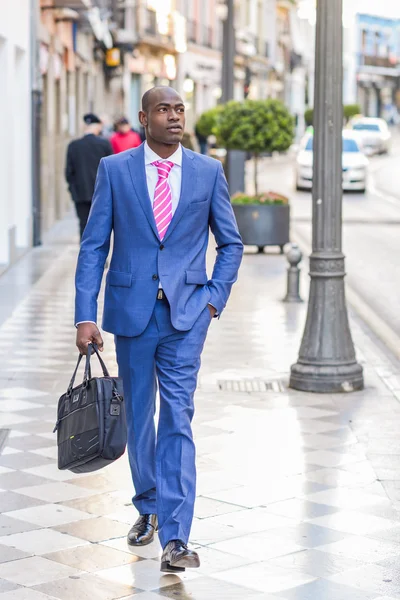 Hombre de negocios negro caminando por la calle con un maletín moderno —  Fotos de Stock