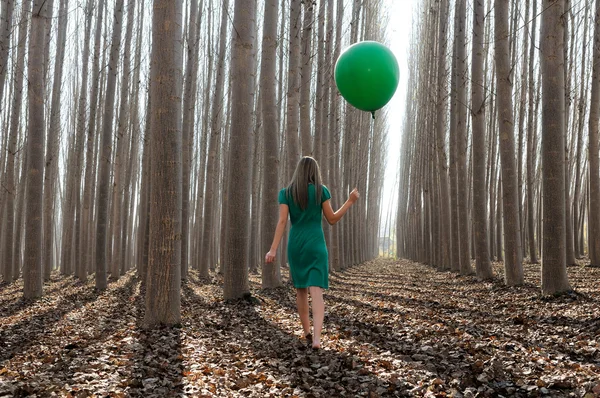 Menina loira bonita, vestida de verde, andando na floresta — Fotografia de Stock