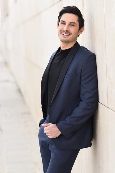 Attractive young businessman in urban background — Stock Photo, Image