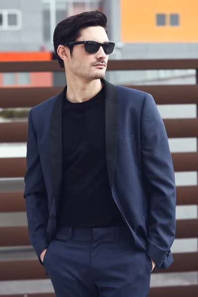 Man, modell av mode, klädd i modern kostym och solglasögon. — Stockfoto