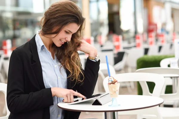 Vrouw kijken naar haar Tablet PC computer aanbrengen in een bar — Stockfoto