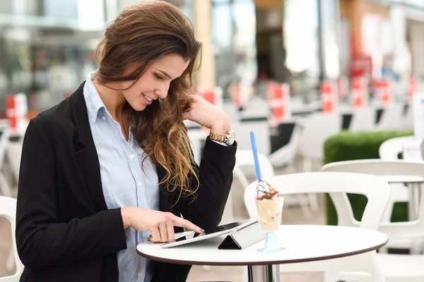 Frau schaut auf ihren Tablet-Computer, der in einer Bar steht — Stockfoto