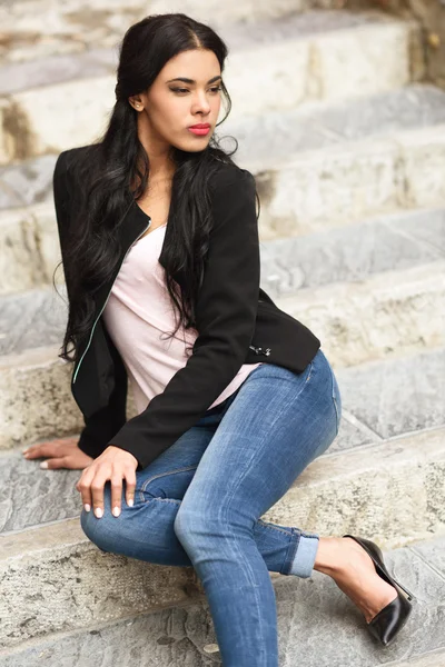 Hispanische junge Frau in lässiger Kleidung im urbanen Hintergrund — Stockfoto
