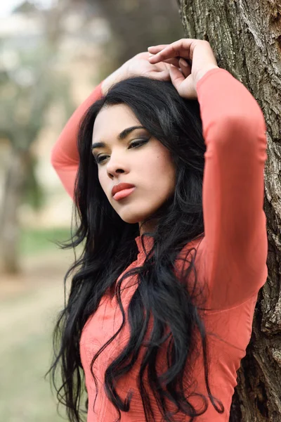 Mulher vestindo vestido laranja em um parque urbano — Fotografia de Stock