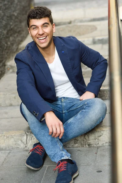 Joven guapo con ojos azules posando cerca de una pared —  Fotos de Stock