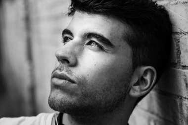 Bir duvara yakın poz mavi gözlü yakışıklı genç