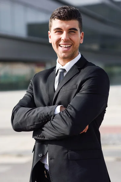 Junger Geschäftsmann in der Nähe eines Bürogebäudes mit schwarzem Anzug — Stockfoto