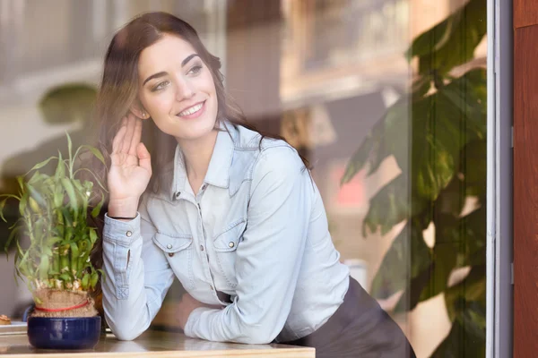 Frau sitzt drinnen in städtischem Café und schaut aus dem Fenster — Stockfoto