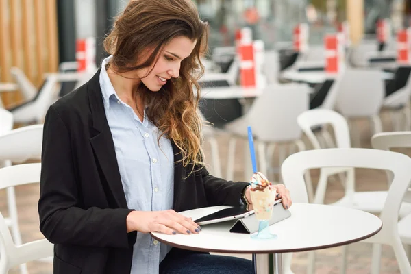 Mujer mirando su tableta situada en un bar — Foto de Stock