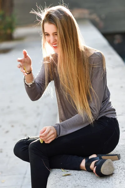 Fille blonde heureuse souriant en arrière-plan urbain — Photo