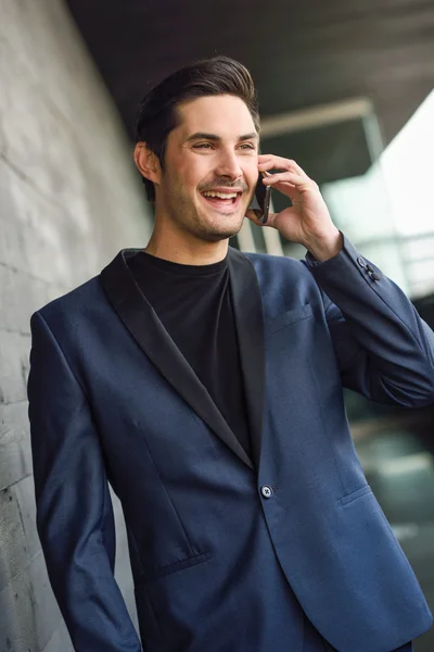 Aantrekkelijke jonge zakenman aan de telefoon in een kantoorgebouw — Stockfoto
