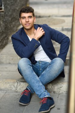 Bir duvara yakın poz mavi gözlü yakışıklı genç