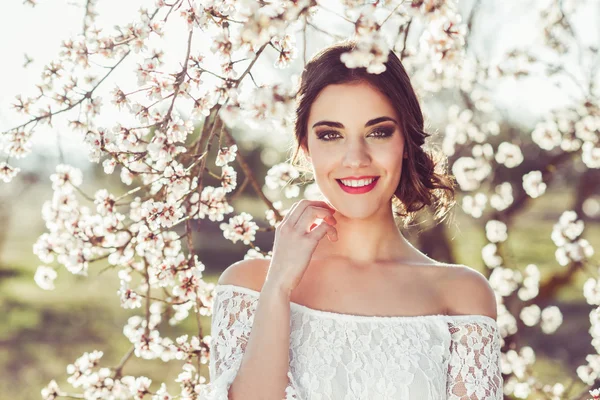 Portret van een jonge vrouw in de bloemrijke tuin in het voorjaar tim — Stockfoto