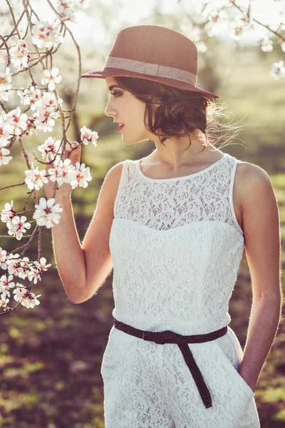 Portret van een jonge vrouw in de bloemrijke tuin in het voorjaar tim — Stockfoto