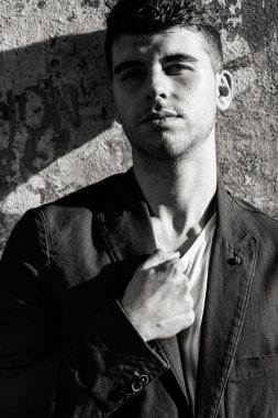 Bir duvara yakın poz mavi gözlü yakışıklı genç