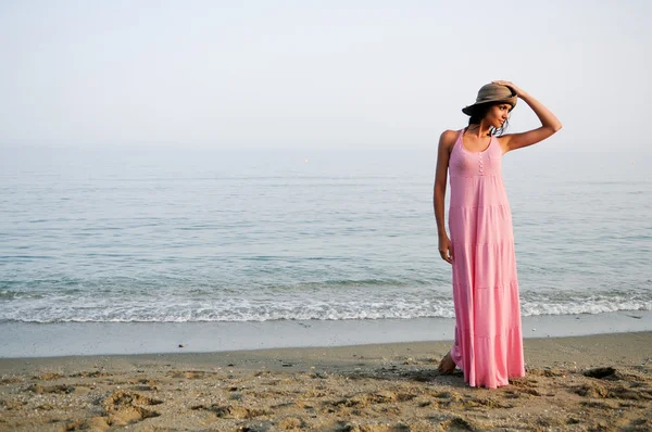 Belle femme avec une longue robe rose sur une plage tropicale — Photo