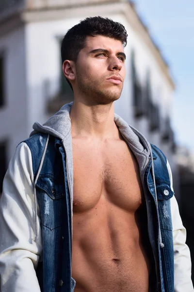 Handsome young man with blue eyes posing in urban background — Stock Photo, Image