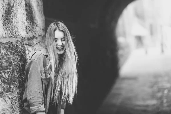 Glücklich blondes Mädchen lächelt im städtischen Hintergrund — Stockfoto